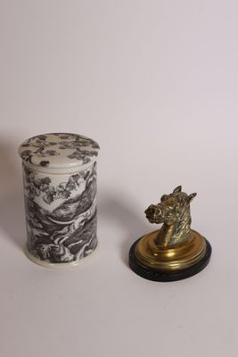un petit vase et une petite statue posés sur une table