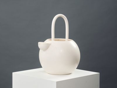 un vase blanc orné d'un nœud sur le dessus