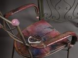 a small table with two chairs and a vase on top of it