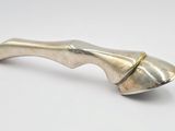 un petit objet argenté sur une surface blanche