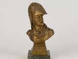 un buste en bronze représentant un homme portant un casque, posé sur un socle en marbre