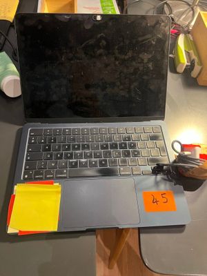 a laptop computer sitting on a desk with sticky notes on it