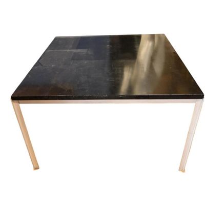 une image représentant une table avec un plateau noir et des pieds dorés