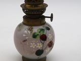 un petit vase en verre orné de fleurs, posé sur une surface blanche