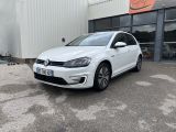 une Volkswagen e-Golf blanche garée devant un immeuble