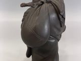 statue of a woman with a bag on her back