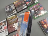a person holding a video game in front of a bunch of other video games