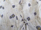 a white dress with blue and yellow flowers on it