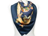 a woman wearing a blue scarf with an image of a bird on it