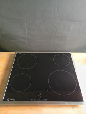 une plaque de cuisson noire et argentée posée sur une table en bois