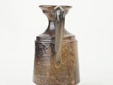 a brown vase with a handle on a white background