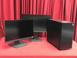 two computer monitors on a red table with red curtains