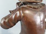bronze statue of a man with a hat on his head holding a baseball bat