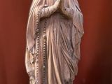 a statue of a woman holding a rosary on a table
