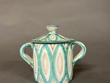 teal and white ceramic teapot with lid on grey background
