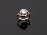 a diamond and gold ring on a black surface
