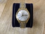 an image of a gold and silver wrist watch on a blue velvet cuff
