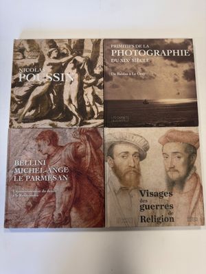 quatre livres posés sur une table blanche, sur fond blanc