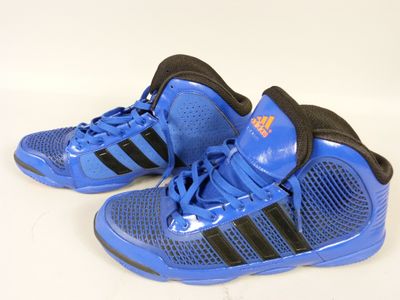 Des chaussures adidas sur une surface blanche, avec un fond blanc