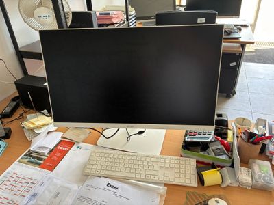 un bureau sur lequel se trouvent un écran d'ordinateur, un clavier, une souris et d'autres objets
