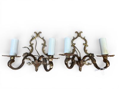 four candle holders are hanging on a wall in a row