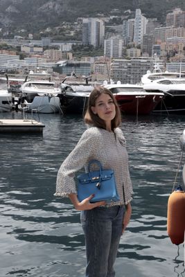 une femme debout sur un quai, une valise à la main