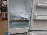 a white refrigerator with its door open in a warehouse