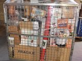 a metal cart with many items in it in a warehouse