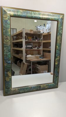 un miroir posé sur une table devant une étagère