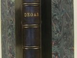 an old book with a blue cover sitting on top of a white table