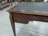 a desk with a glass top and a chair in the background