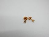 a pair of gold stud earrings on a white surface