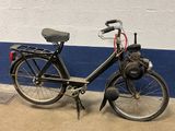 a black bicycle parked next to a blue and white wall
