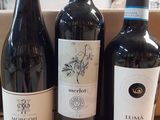 three bottles of wine sitting on a table next to a cardboard box