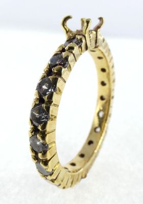 a close up of a gold ring with black diamonds on it