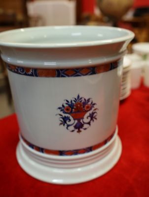 un vase blanc orné d'un motif bleu et orange