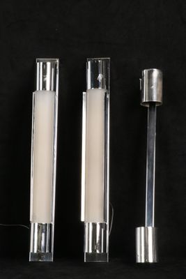 trois bougies sont alignées sur une surface noire, sur fond noir