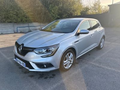 une voiture argentée garée dans un parking à côté d'un bâtiment
