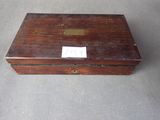 an old wooden box with a tag on it sitting on a table