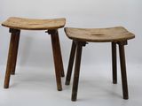 two wooden stools sitting next to each other on a white surface