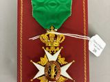 une image représentant une boîte rouge avec une médaille en or et un ruban vert