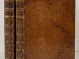 an old book sitting on top of a table next to a white wall