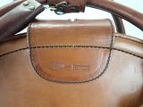a close up of a brown leather bag with a handle