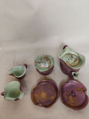 plusieurs pièces de poterie violettes et vertes posées sur une surface blanche