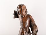 wooden statue of a boy holding a bird in his hand