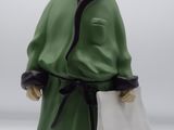 a figurine of a man in a green robe holding a piece of paper