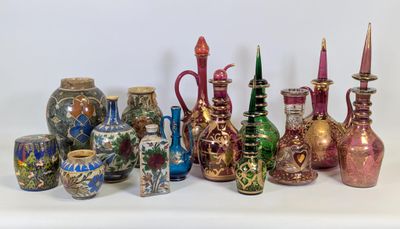 de nombreux vases de différentes couleurs posés sur une surface blanche