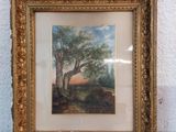 an old picture of a tree in a gold frame on a table