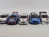 a group of toy cars lined up in a row on a white surface