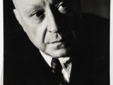 black and white photograph of a bald man in a suit and tie